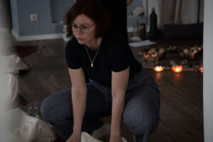 Valentina kniet während eines Breathwork-Retreats neben einer liegenden Person.